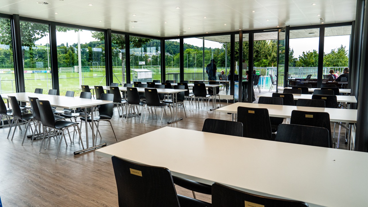 Heller Gastraum der FC Beiz mit Blick auf den Sportplatz